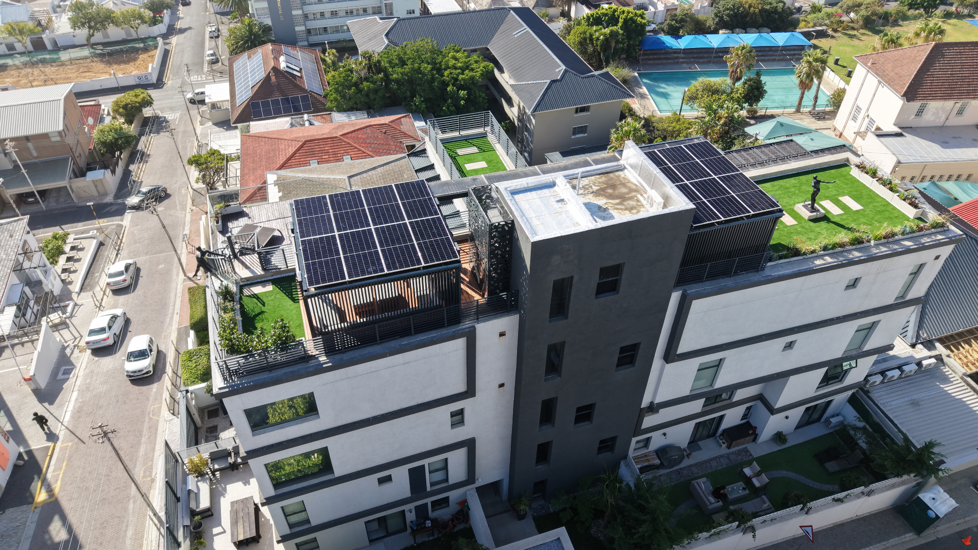 Aerial view of solar panels across several roof sections of a Sea Point apartment building