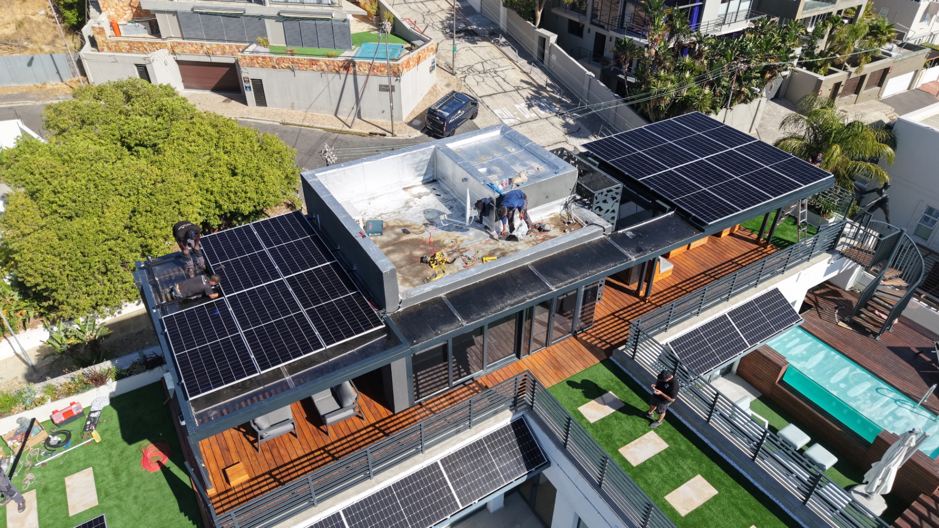 Cape Town Solar crew installing solar panels on the penthouse rooftop in Sea Point, seen from a drone