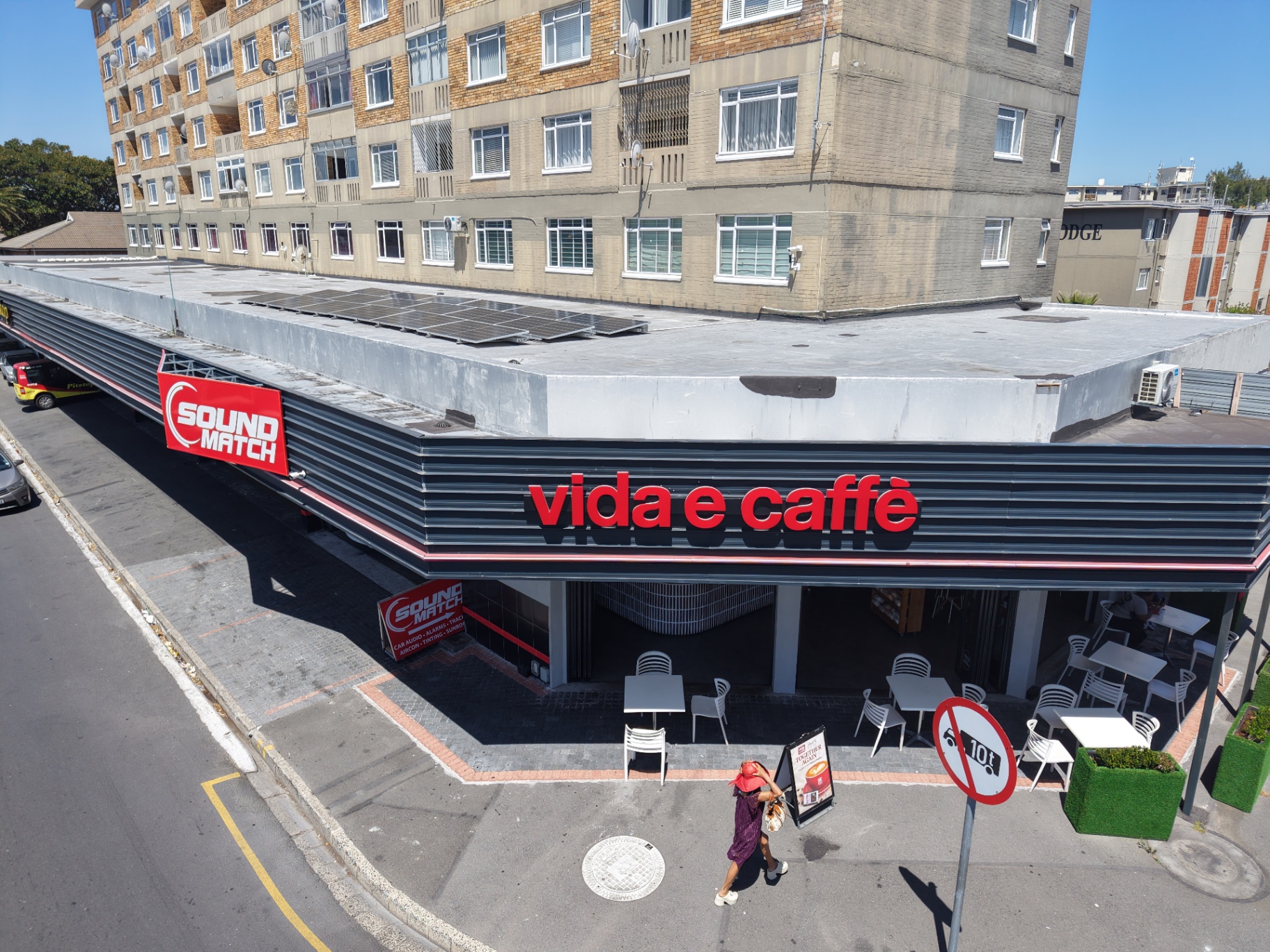 Drone view of the vida e caffè building with solar panels on the flat roof above the shopfront