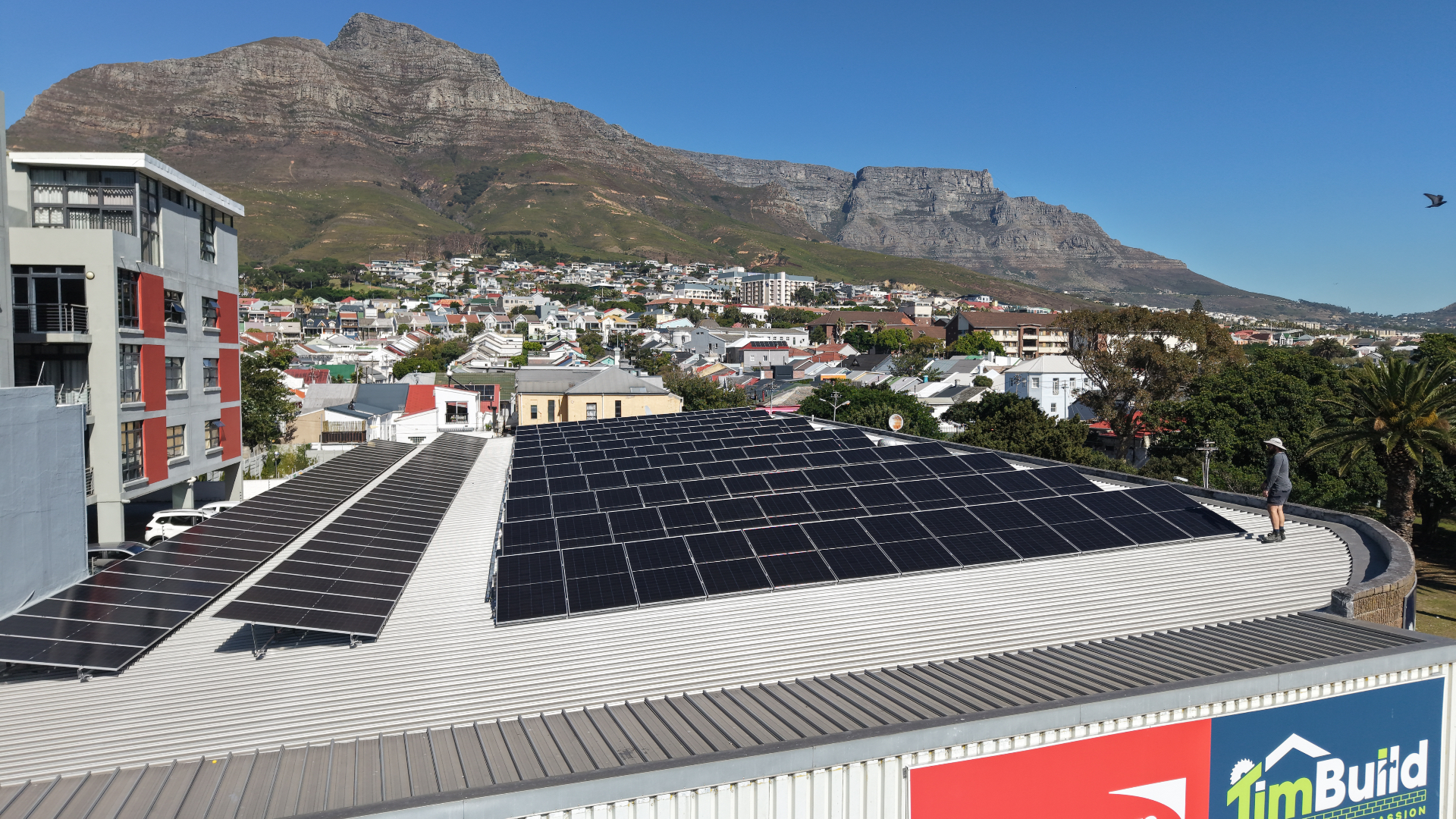 Large commercial solar array on the TimBuild roof with Table Mountain behind